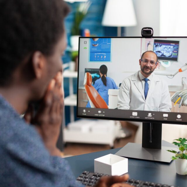 Online healthcare checkup of african american guy Patient meeting with a doctor through a video visit on a home computer