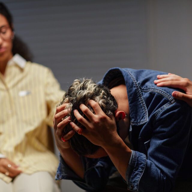 Young man receiving comfort and support from people around him