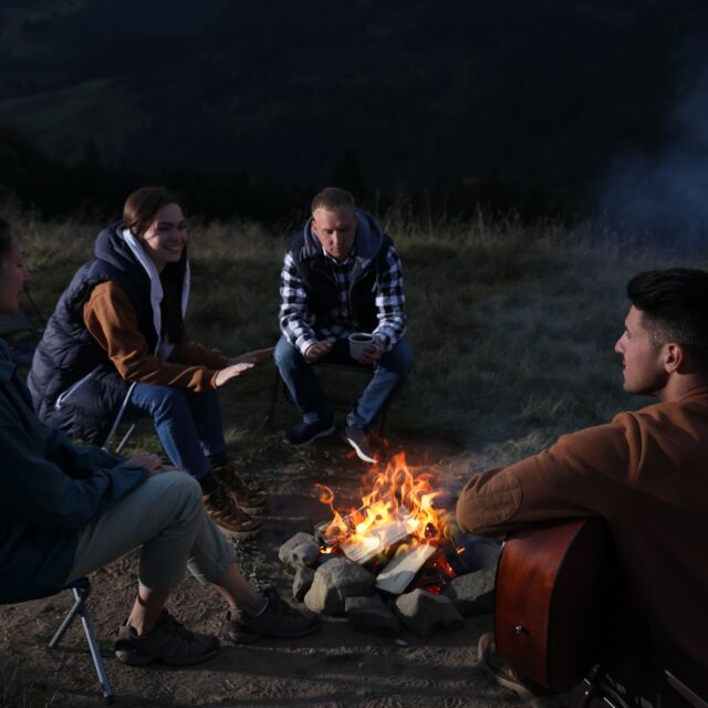 friends-gather-around-campfire-in-mountainous-rura-2026-09-22-13-12-17-utc (1) Group of friends talking around a campfire in the mountains
